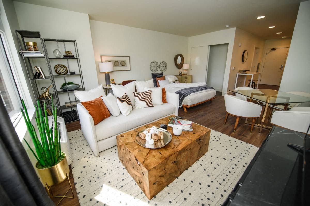 a living room with a couch and a table in front of a bedroom